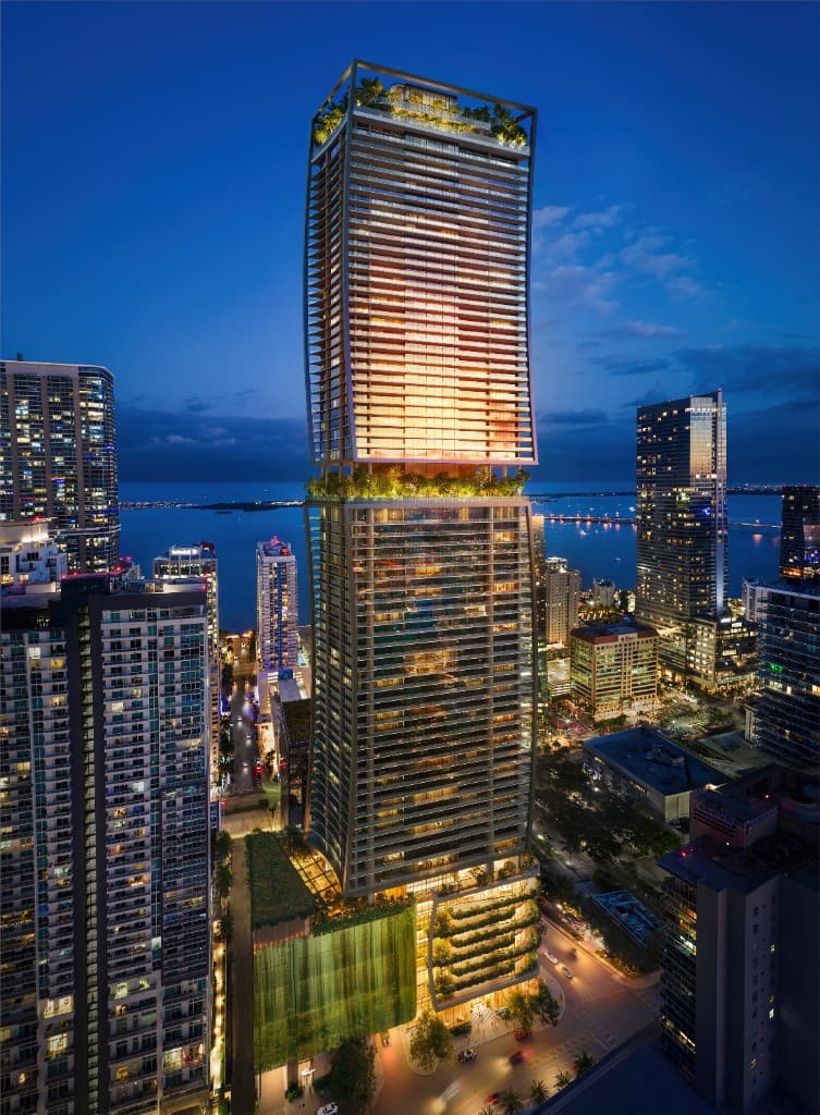 ORA by Casa Tua tower illuminated at dusk above the Brickell skyline and Biscayne Bay